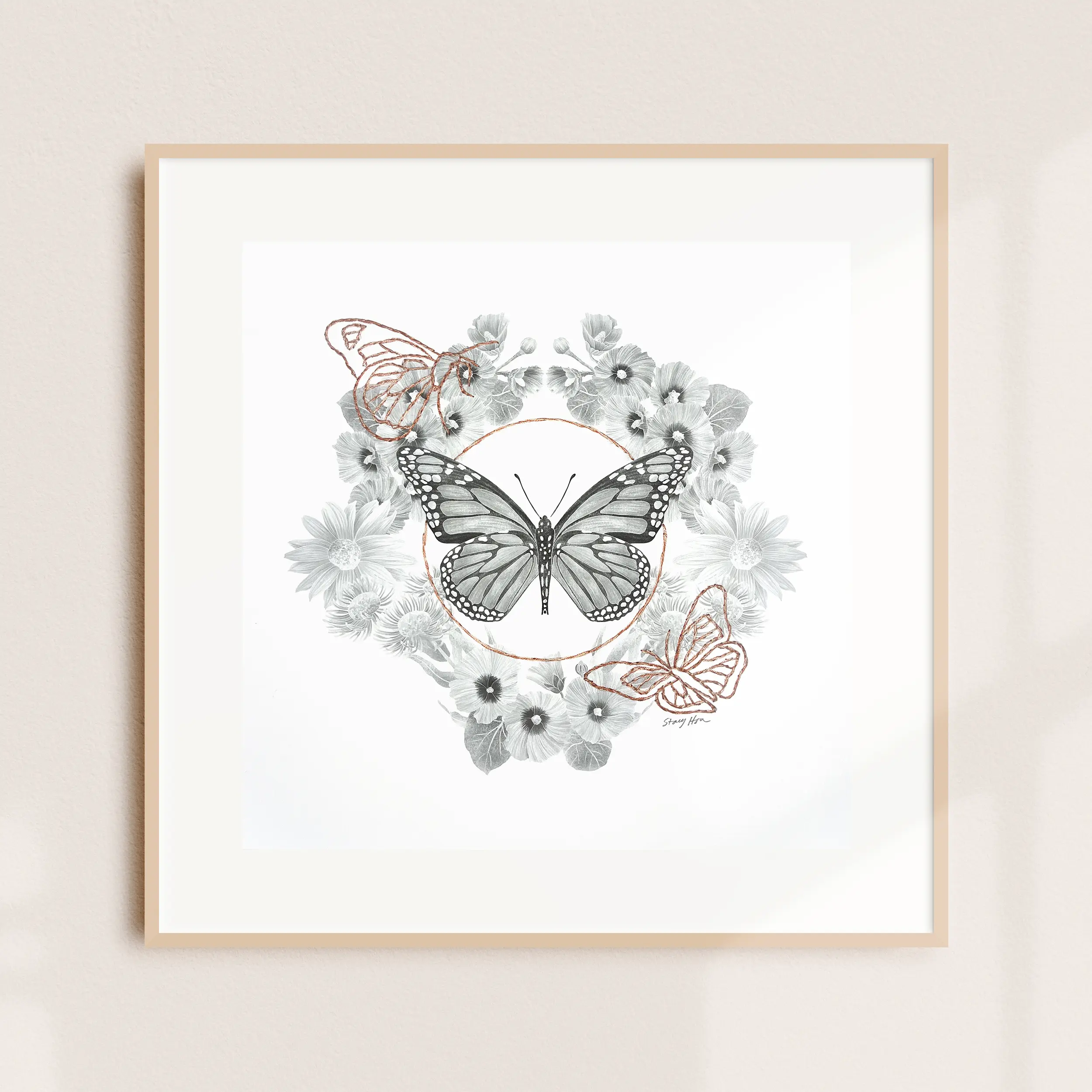 A framed illustration of a butterfly wreath