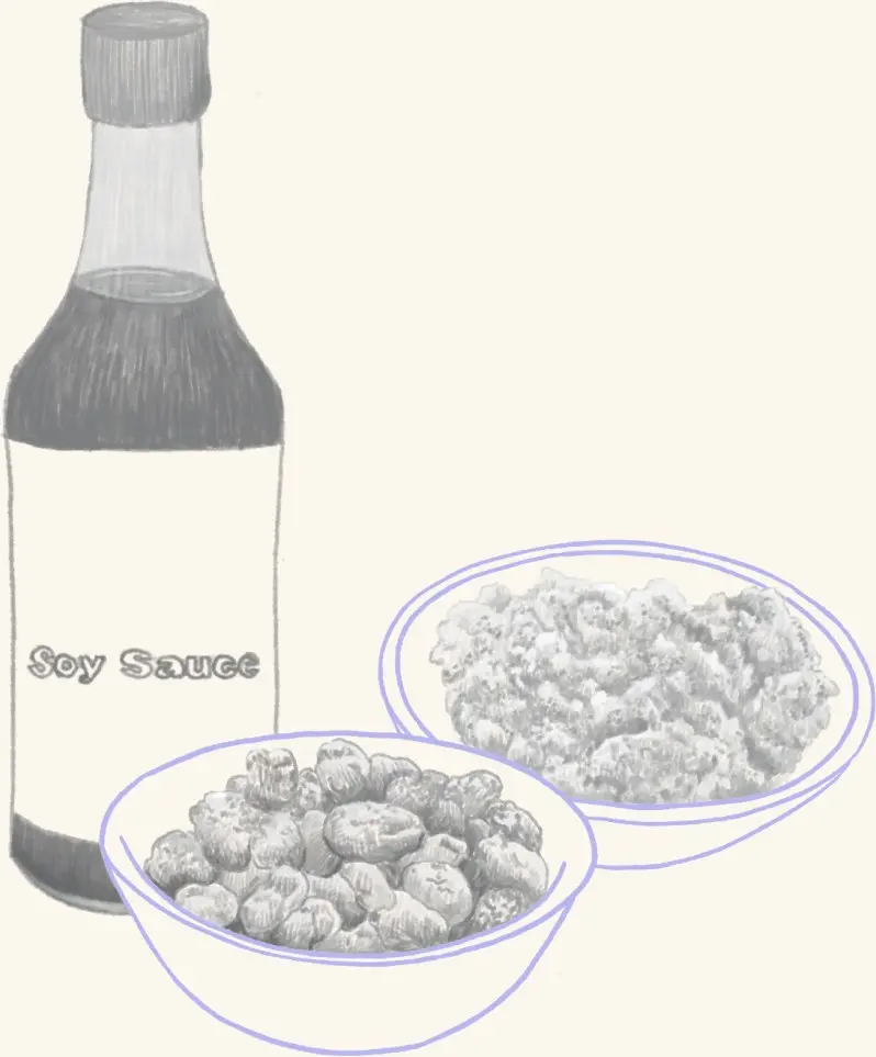 A bottle of soy sauce beside a bowl of fermented beans