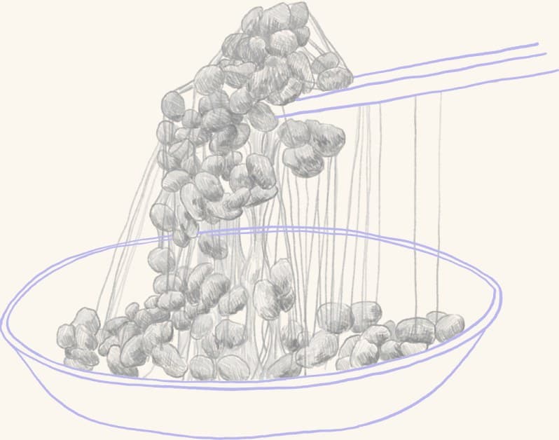 Natto lifted with chopsticks in sticky strands