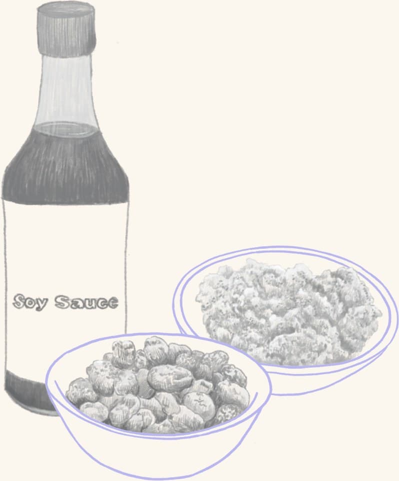 A bottle of soy sauce beside a bowl of fermented beans